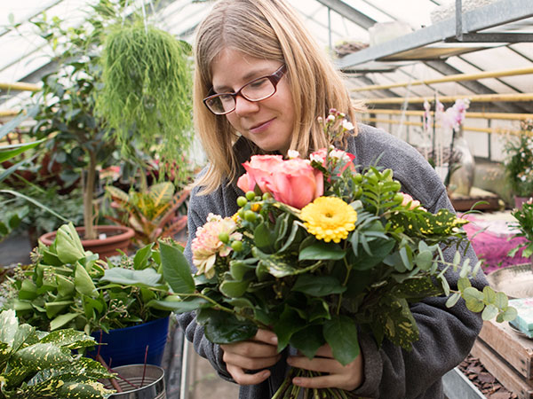 Bild einer Mitarbeiterin mit Blumenstrauss